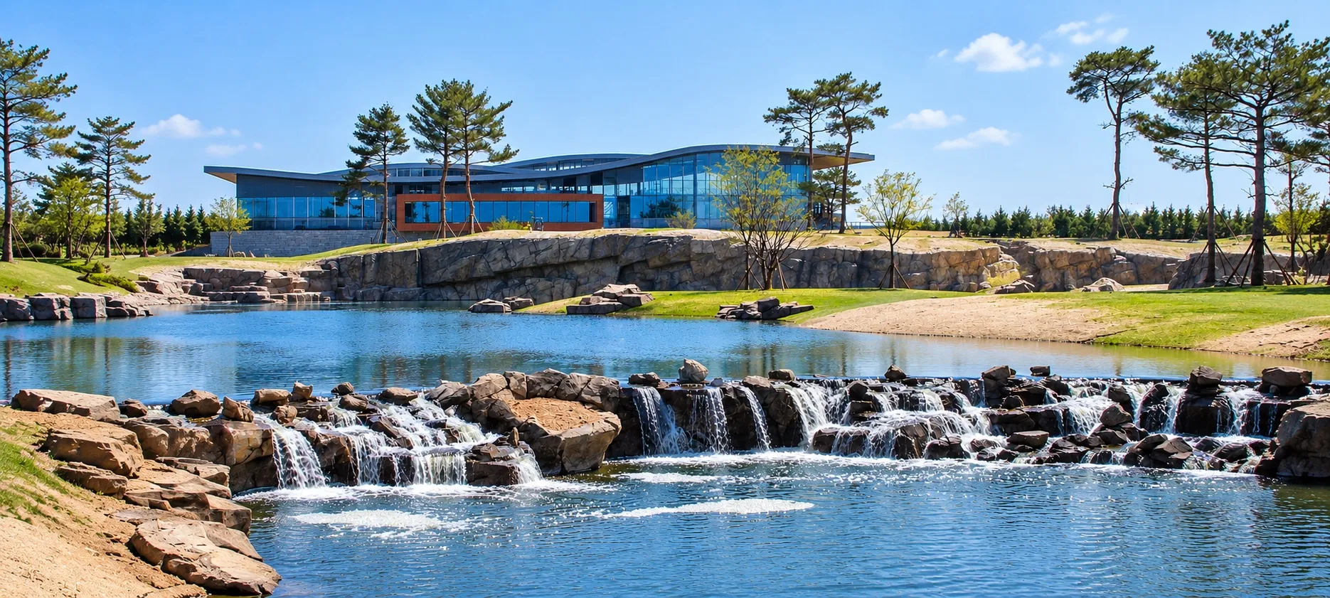 Landscaped pond with koi, planted margins and a rock cascade returning aerated water