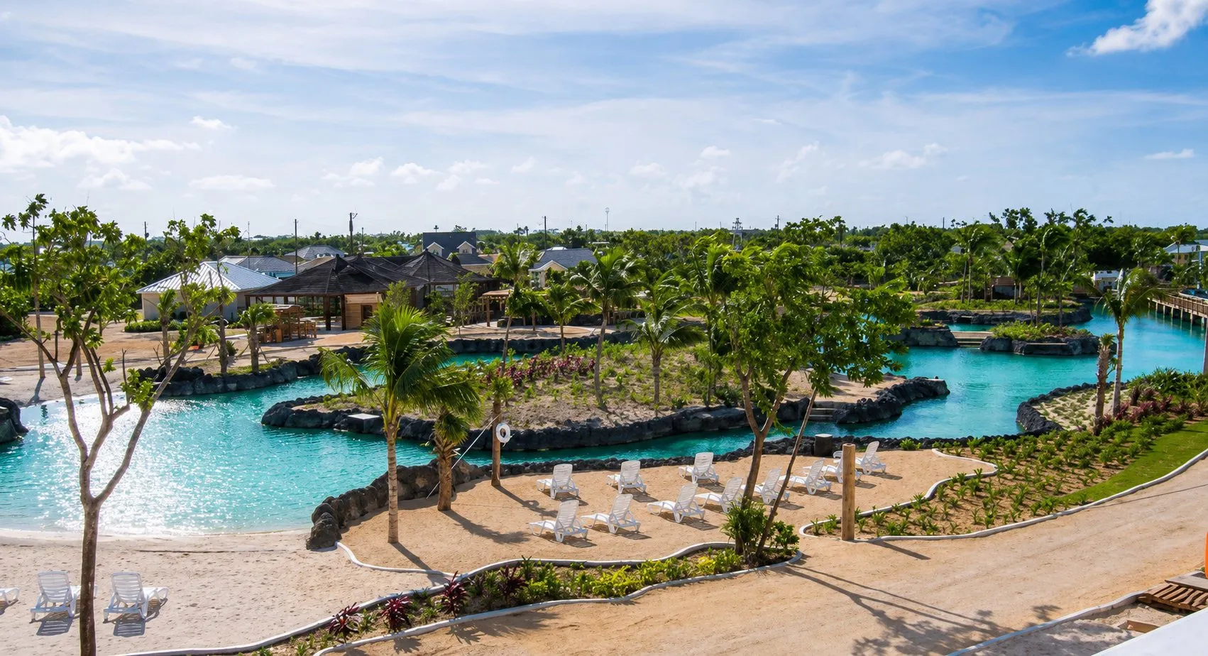 Resort swimming lagoon with sand beach, planted islands and lounge terraces